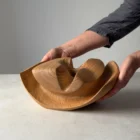 Hand-carved cherry wood ikebana vase shown in hands for scale and proportion reference