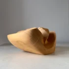 Detail of preserved natural cracks and flowing grain on hand-carved cherry wood sculpture vase