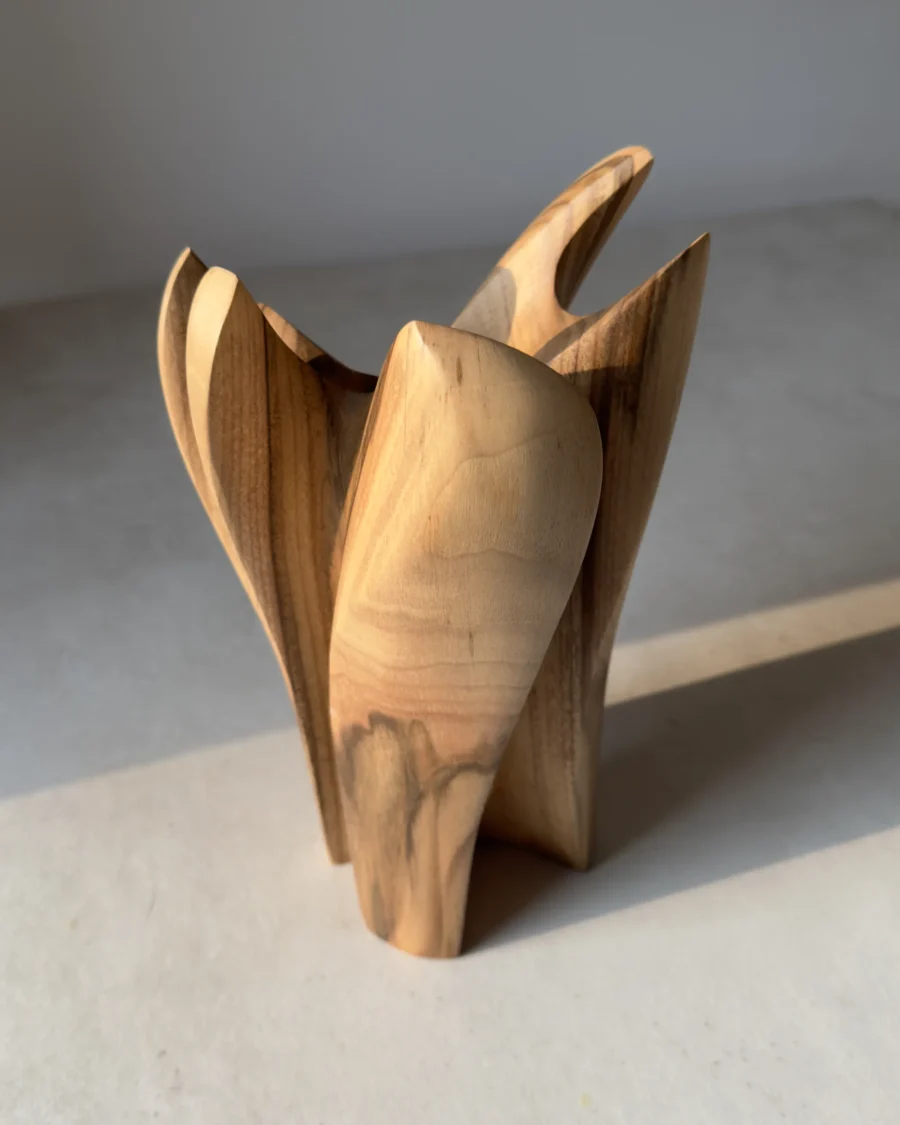quiet-bloom-organic-modern-vase Side view of a hand carved walnut vase with layered petal-like forms