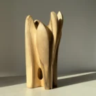 quiet-bloom-sculptural-wood-vase-opening Walnut wood vase featuring a sculptural opening through the base and flowing organic lines