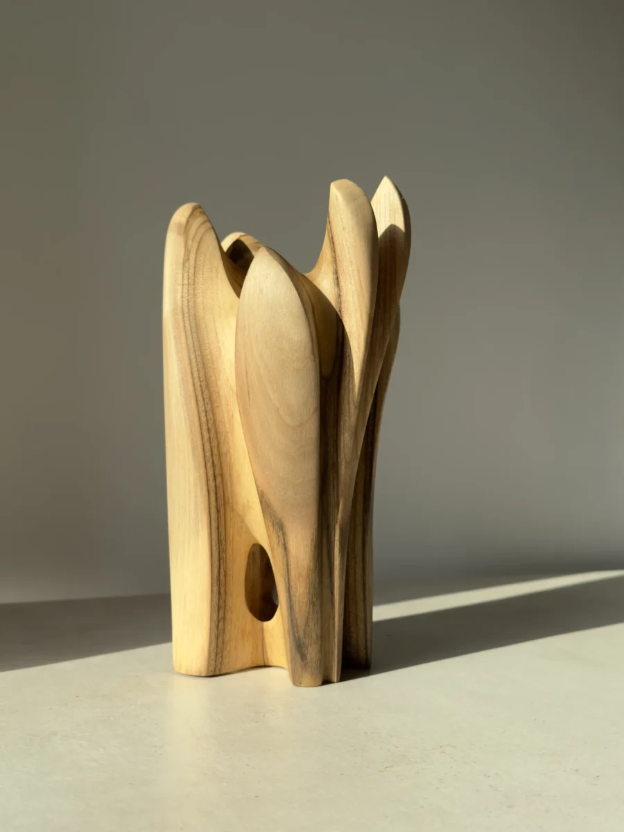 quiet-bloom-sculptural-wood-vase-opening Walnut wood vase featuring a sculptural opening through the base and flowing organic lines