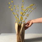 quiet-bloom-styled-walnut-vase Hand carved walnut vase styled with decorative yellow flowering branches in natural light