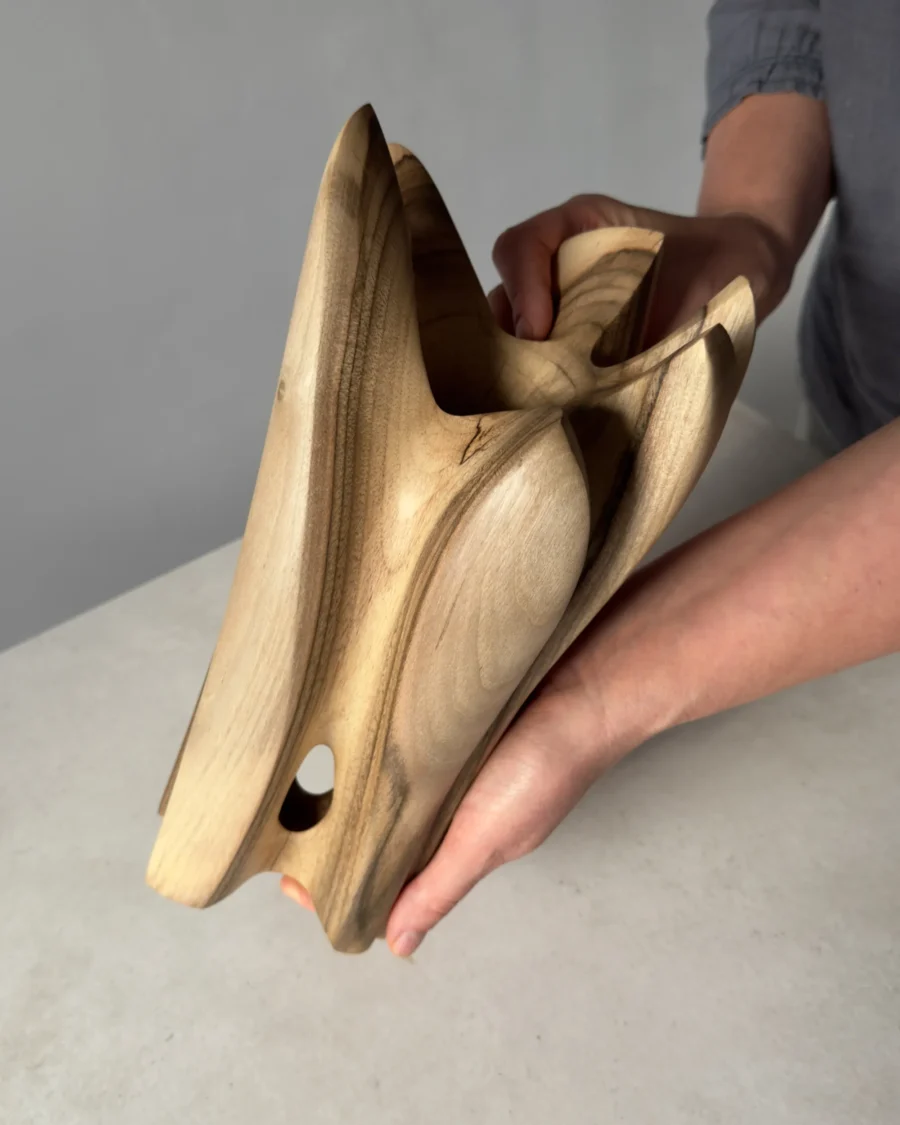 quiet-bloom-walnut-sculpture-vase Hand carved walnut wood vase held in one hand showing scale and proportions of the sculptural form