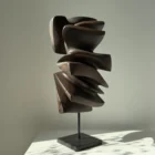 Shaped by Silence hand-carved apple wood sculpture on granite base viewed from the front in natural light.