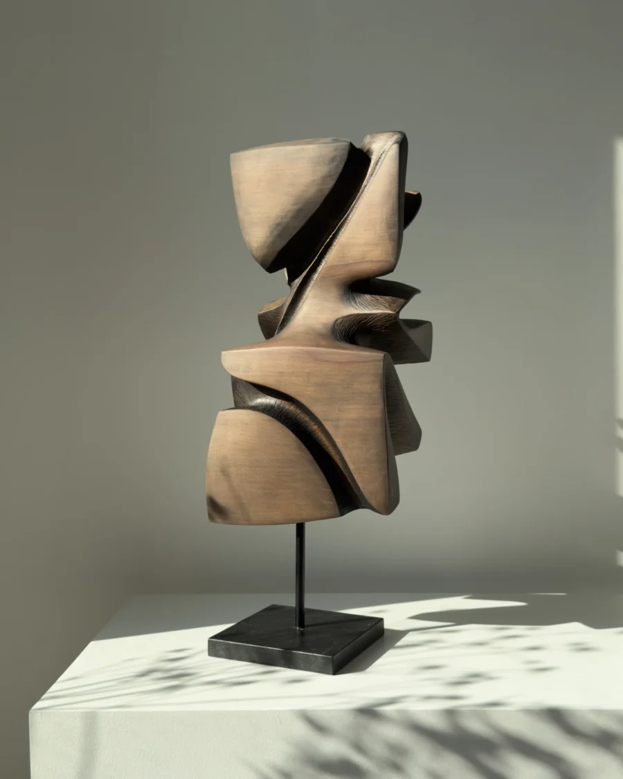 Rear view of Shaped by Silence sculpture revealing smooth planes and deep carved recesses.
