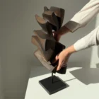 Shaped by Silence abstract apple wood sculpture shown with a hand to illustrate scale and proportions.