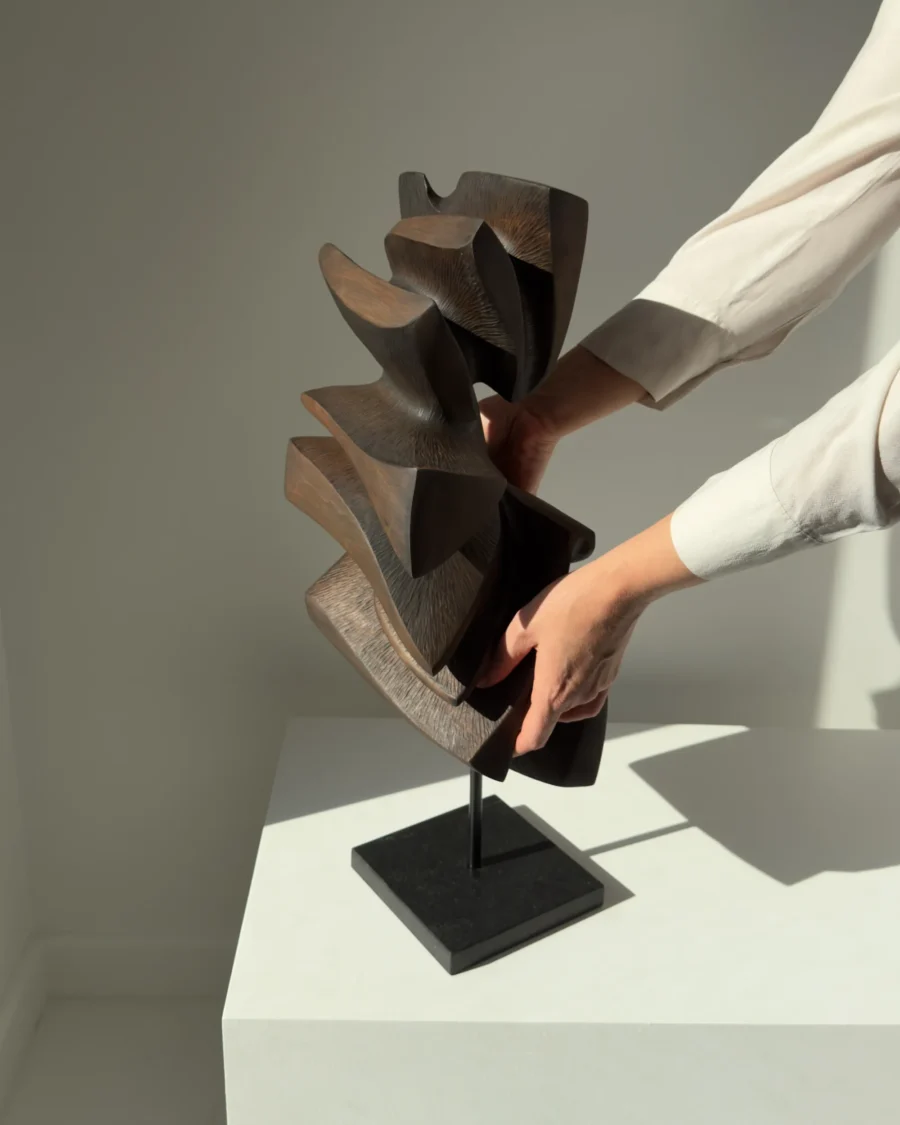 Shaped by Silence abstract apple wood sculpture shown with a hand to illustrate scale and proportions.