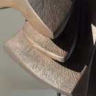 Close-up of carved grain and textured surfaces on Shaped by Silence apple wood sculpture.