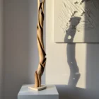 silent-axis-sculpture-light-and-shadow Silent Axis walnut wood sculpture illuminated by warm sunlight creating organic shadow patterns