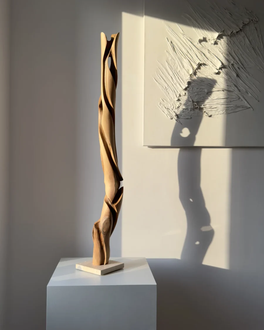 silent-axis-sculpture-light-and-shadow Silent Axis walnut wood sculpture illuminated by warm sunlight creating organic shadow patterns