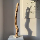 silent-axis-walnut-sculpture-gallery-view Silent Axis tall walnut wood sculpture displayed in natural light with sculptural shadow on wall