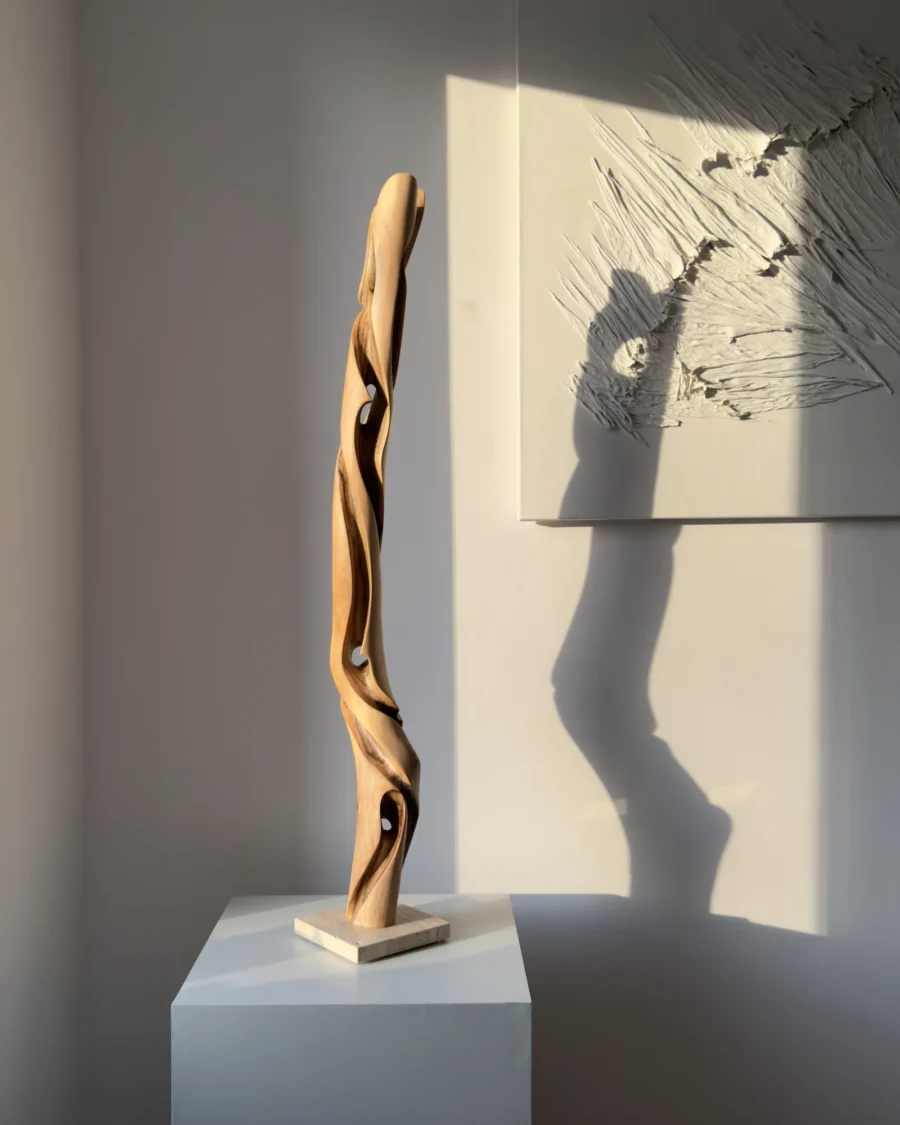 silent-axis-walnut-sculpture-gallery-view Silent Axis tall walnut wood sculpture displayed in natural light with sculptural shadow on wall