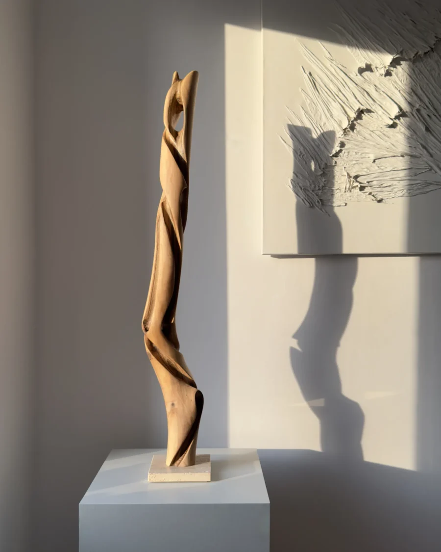 silent-axis-walnut-sculpture-side-opening Side view of Silent Axis abstract walnut wood sculpture with carved opening and travertine stone base