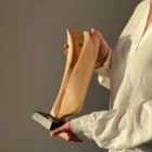 Veil of Air apple wood sculpture held in hands in warm natural light