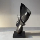 Side profile of the hand-carved apple wood sculpture "Poise", highlighting its sculptural balance and contrasting smooth and textured surfaces.