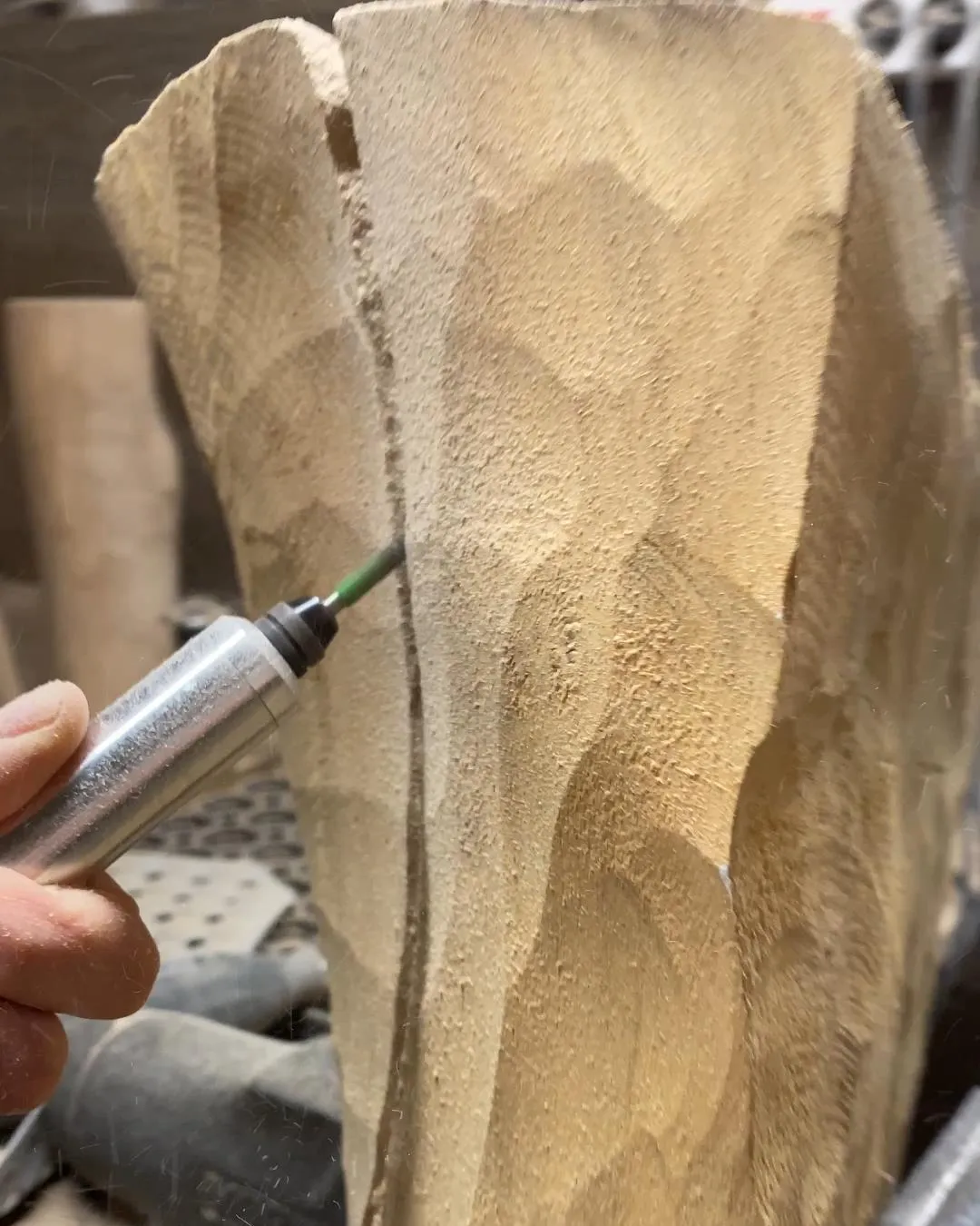 Beginning to shape a solid walnut block using a handheld angle grinder during the carving of Folded Presence.
