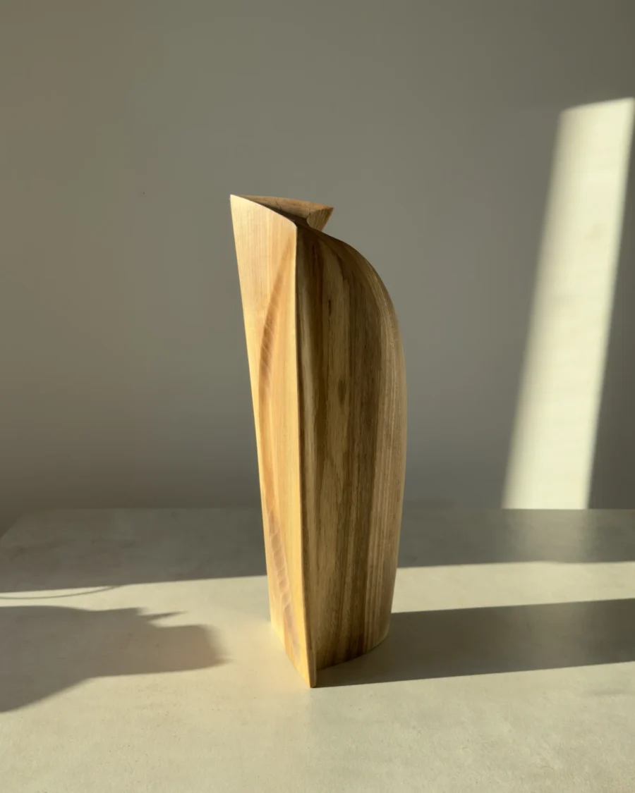 Profile view of Continuum showing its slender architectural silhouette and softly curved outer edge.