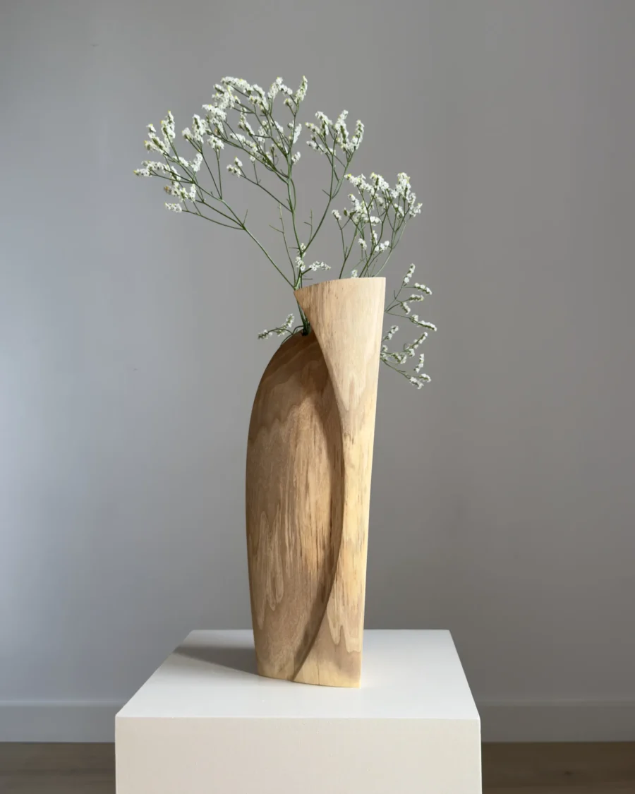 continuum-walnut-vase-fresh-flowers-curved-side Continuum walnut wood sculpture used as a vase with fresh white flowers, showing the broad curved side and asymmetrical top.