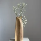 continuum-walnut-vase-side-view-fresh-flowers Continuum abstract walnut vase with fresh white flowers, showing the carved curved line across the front plane.