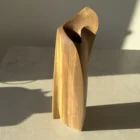 Elevated view of the Continuum walnut sculpture revealing the sculpted top and deep opening for a glass tube