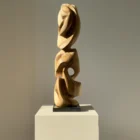 Abstract walnut sculpture viewed from another angle, revealing different organic forms.