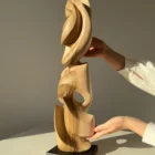 Convergence abstract walnut sculpture shown in hands for scale and proportion.
