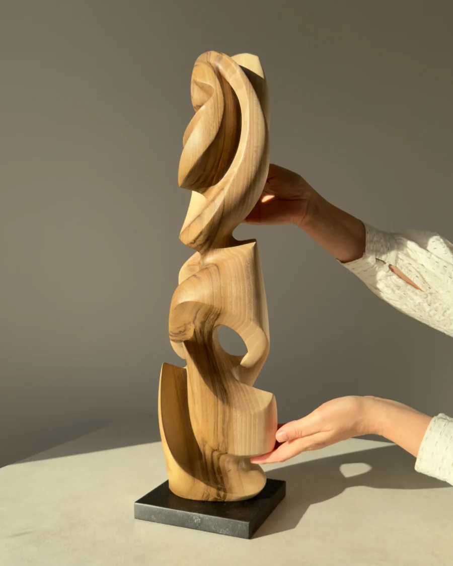Convergence abstract walnut sculpture shown in hands for scale and proportion.