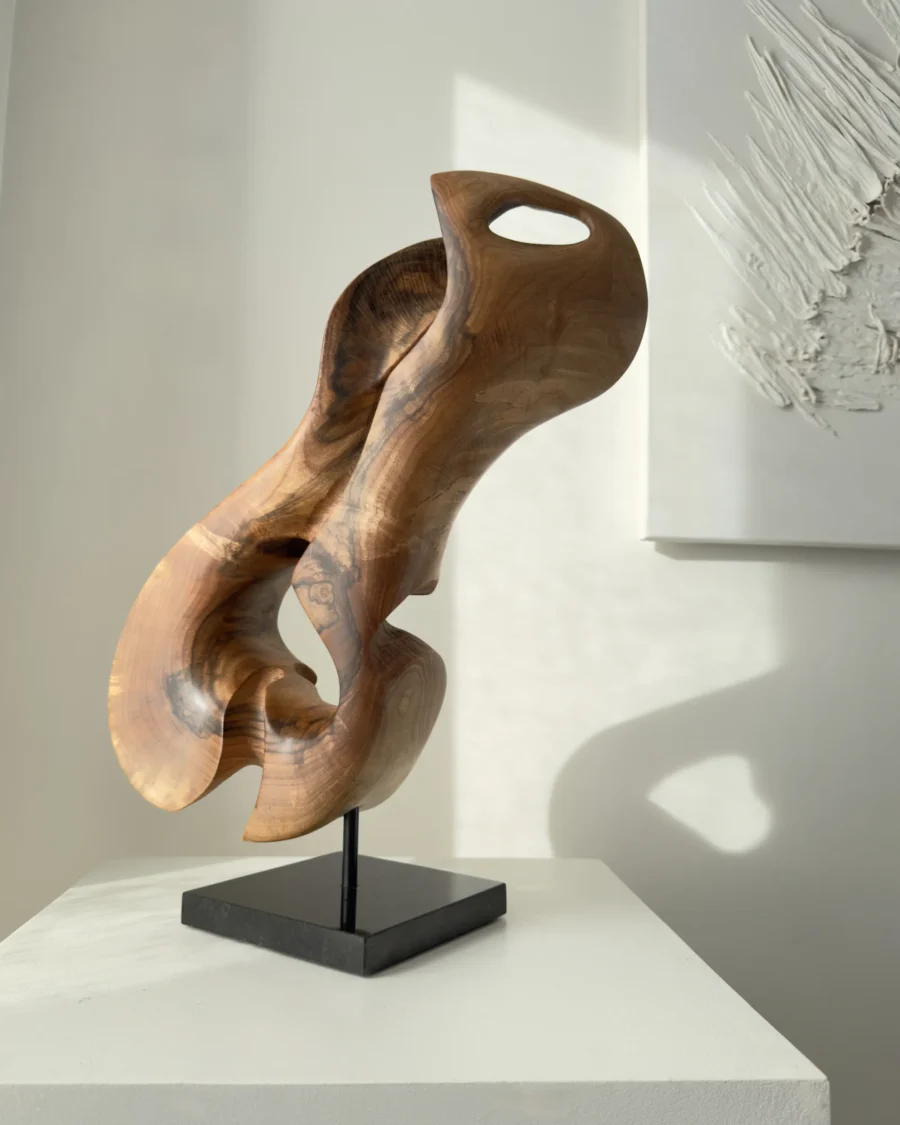 Profile view of Elaren contemporary walnut wood sculpture revealing sculptural curves and the relationship between light and shadow.