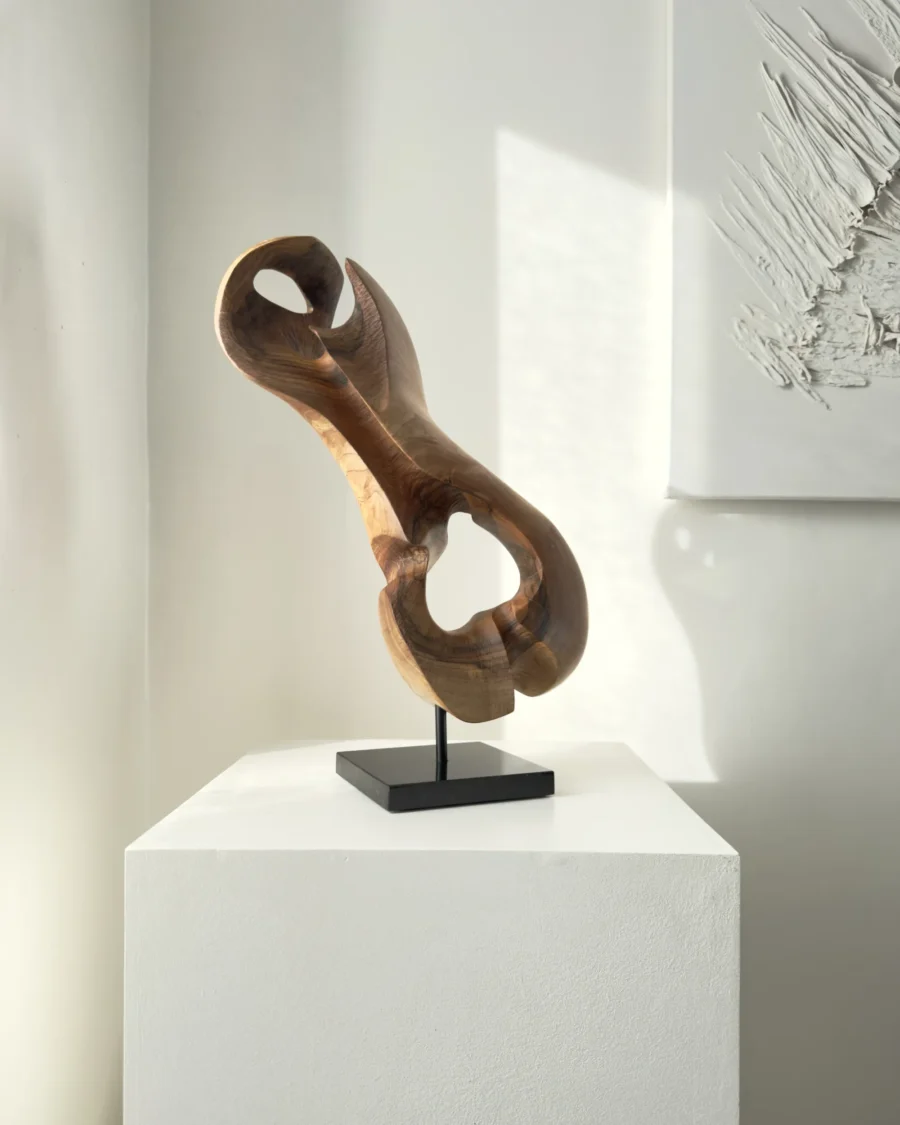 Three-quarter view of Elaren, a hand-carved abstract walnut wood sculpture with flowing organic forms and natural matte finish.