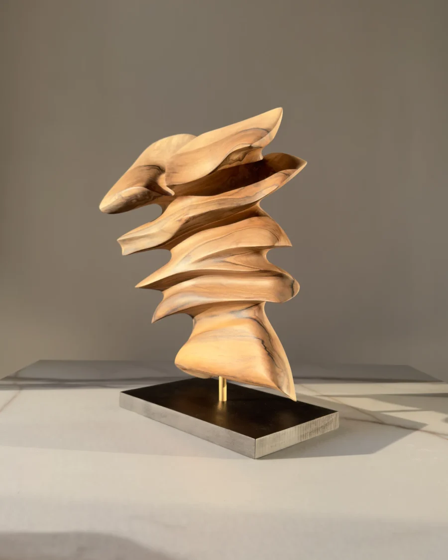 Front view of Fluens, a one-of-a-kind abstract walnut sculpture with flowing layered forms on a black wooden base.