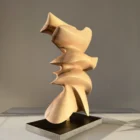 Rear view of Fluens, showcasing the continuous organic form and hand-carved walnut surfaces.