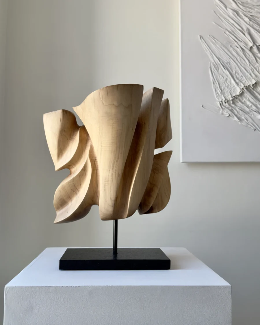 Rear view of Folded Presence revealing layered planes and changing light across the hand-carved walnut surface.