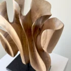 Close-up of Folded Presence highlighting smooth carved curves and the natural figure of solid walnut wood.