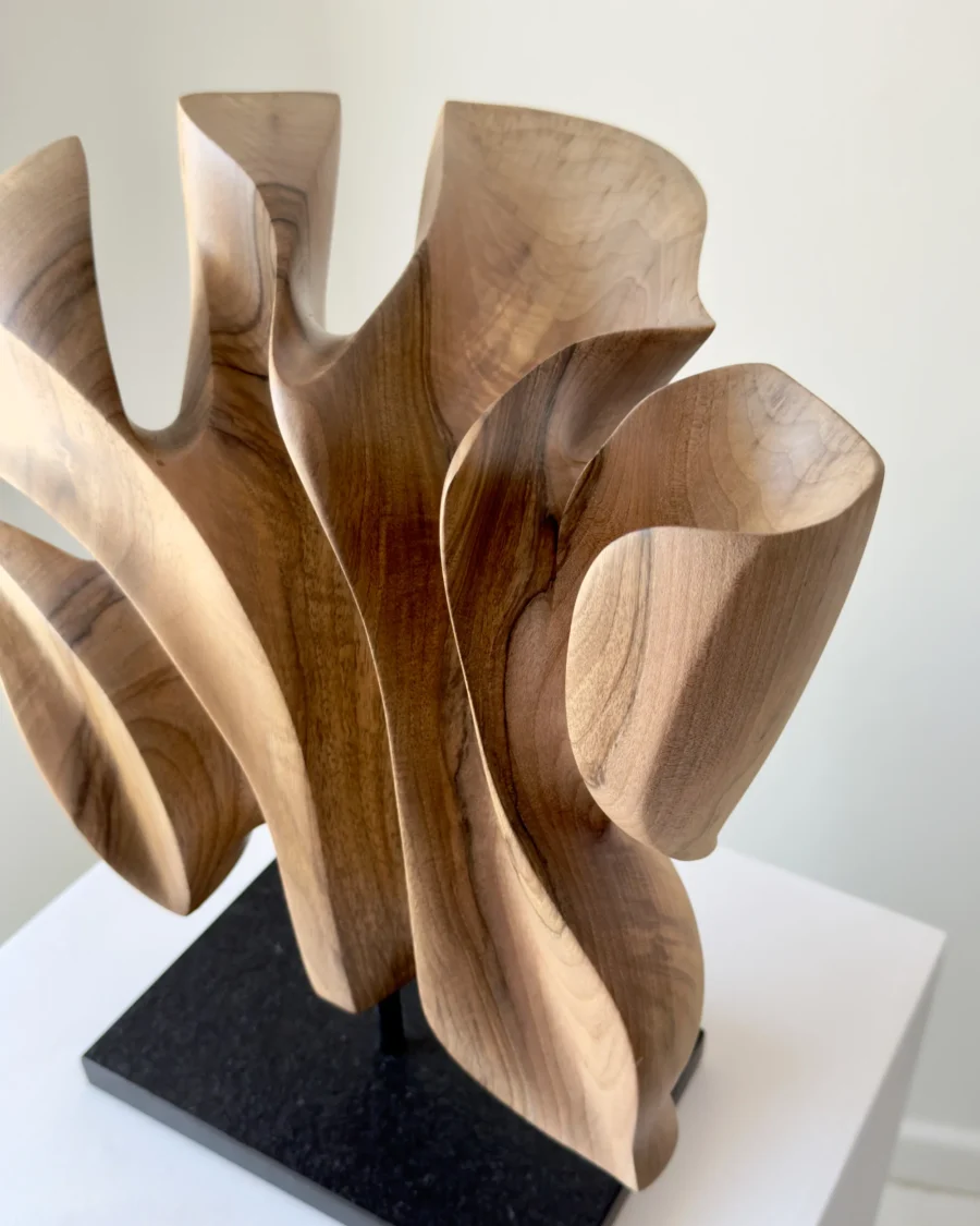 Close-up of Folded Presence highlighting smooth carved curves and the natural figure of solid walnut wood.