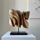 Front view of Folded Presence, an abstract hand-carved walnut wood sculpture with layered organic planes.