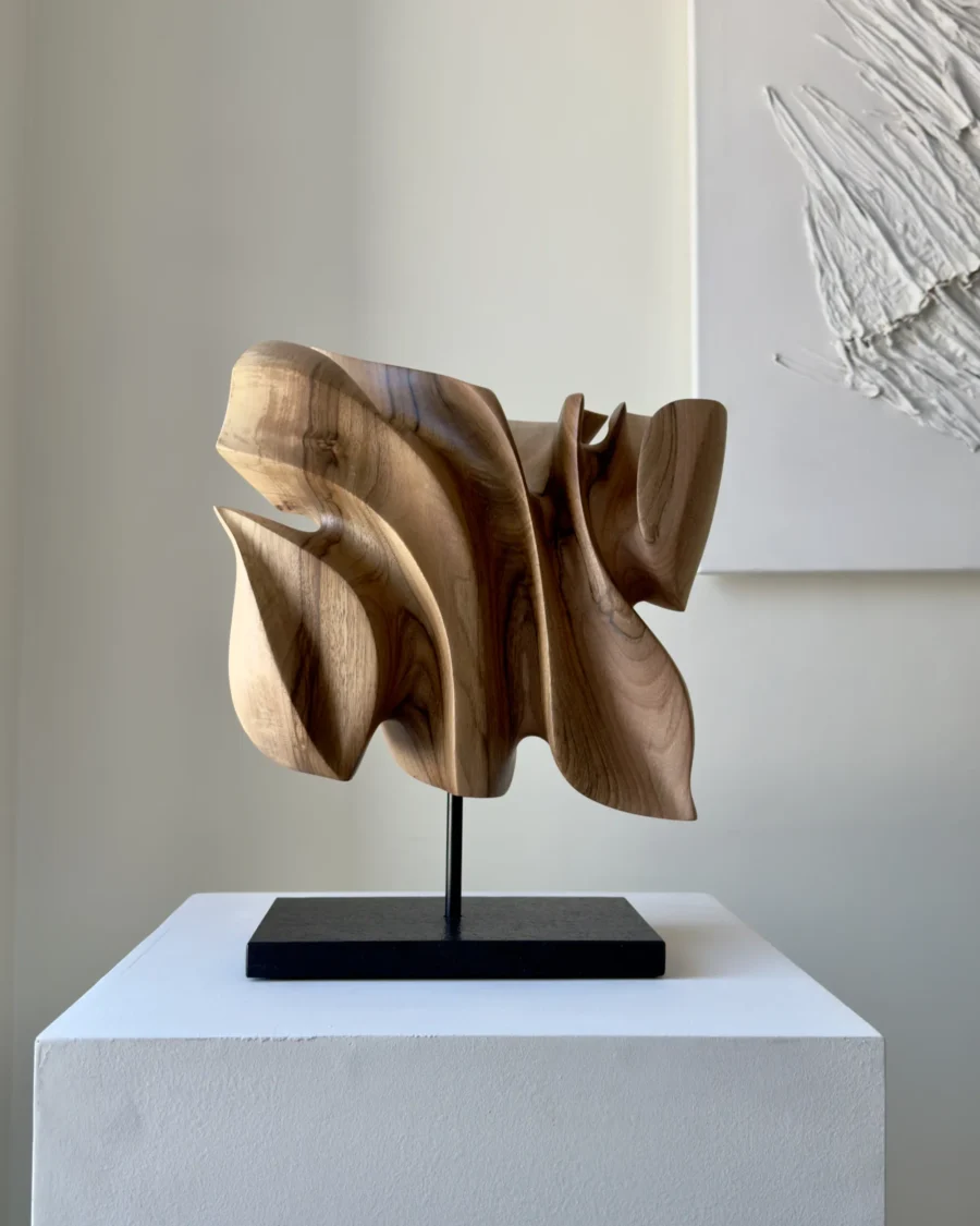 Front view of Folded Presence, an abstract hand-carved walnut wood sculpture with layered organic planes.