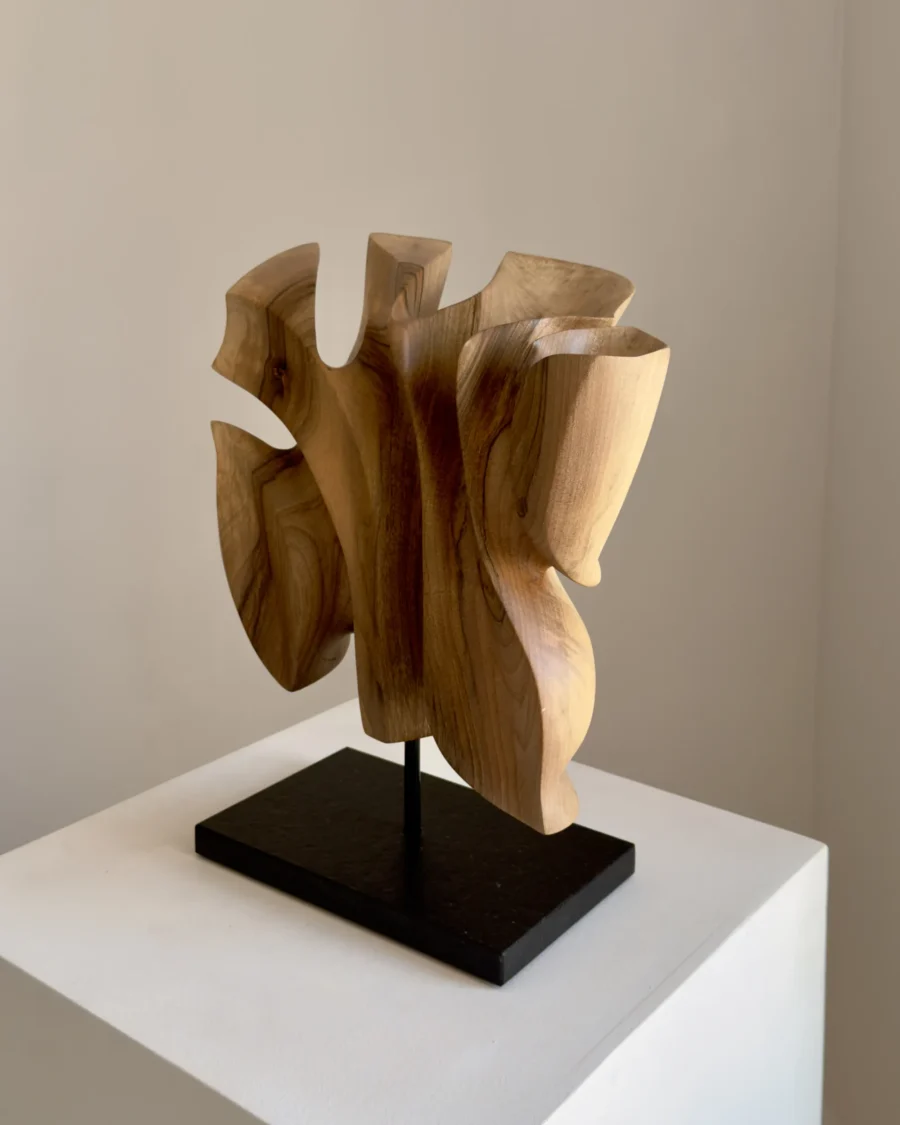 Right-side view of Folded Presence showing folded organic forms carved from a single piece of walnut wood.