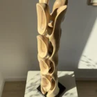 Three-quarter view of Ivory Flow, a hand-carved walnut sculpture photographed in warm natural light.