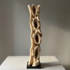 Ivory Flow hand-carved walnut sculpture viewed from the front in soft natural gallery light.