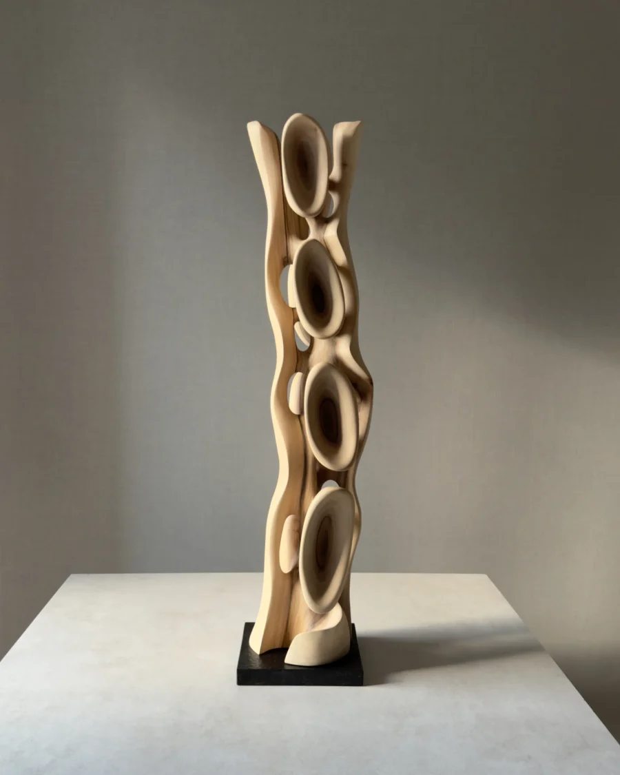 Ivory Flow hand-carved walnut sculpture viewed from the front in soft natural gallery light.