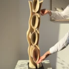 Ivory Flow abstract walnut sculpture shown with hands to illustrate its scale and handcrafted details.