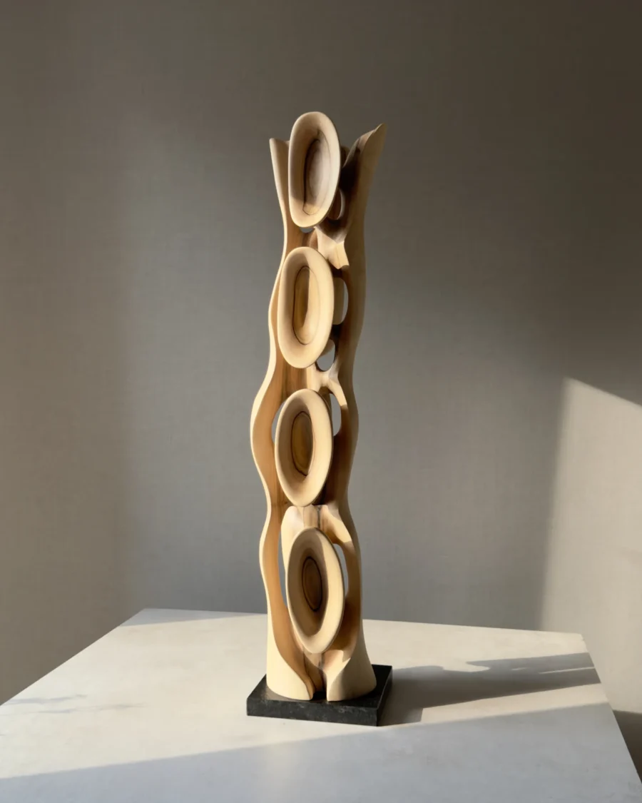 Ivory Flow contemporary walnut sculpture with changing light and shadow across its organic carved forms.