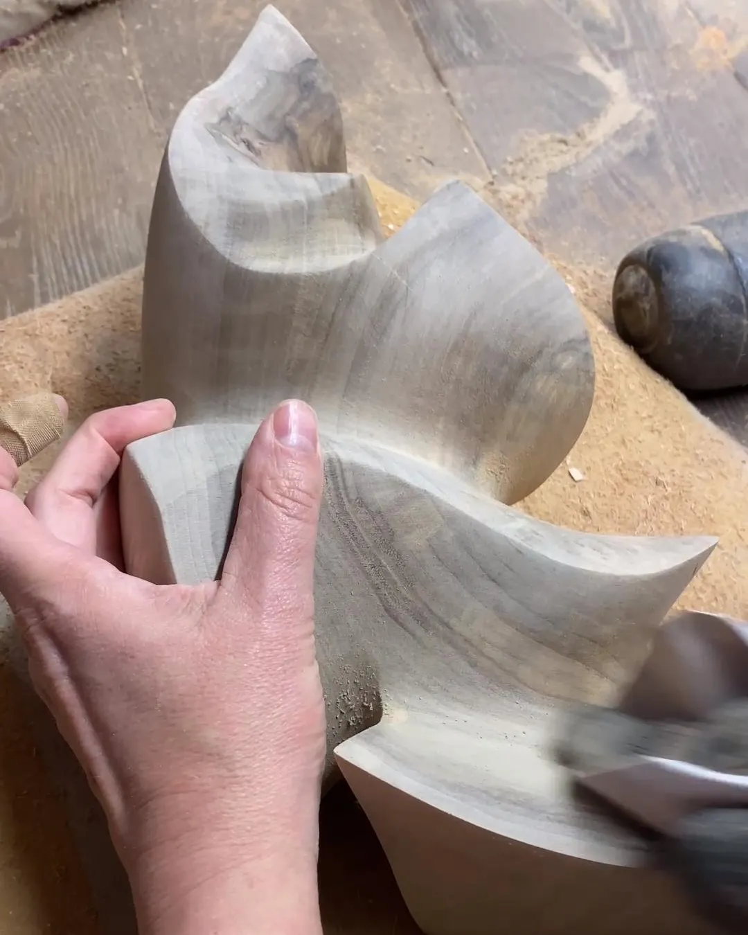 Sanding the flowing surfaces of the walnut sculpture Confluence before the next decision.