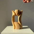 Lumen hand-carved pear wood sculptural vase shown with hands to demonstrate its size and proportions.