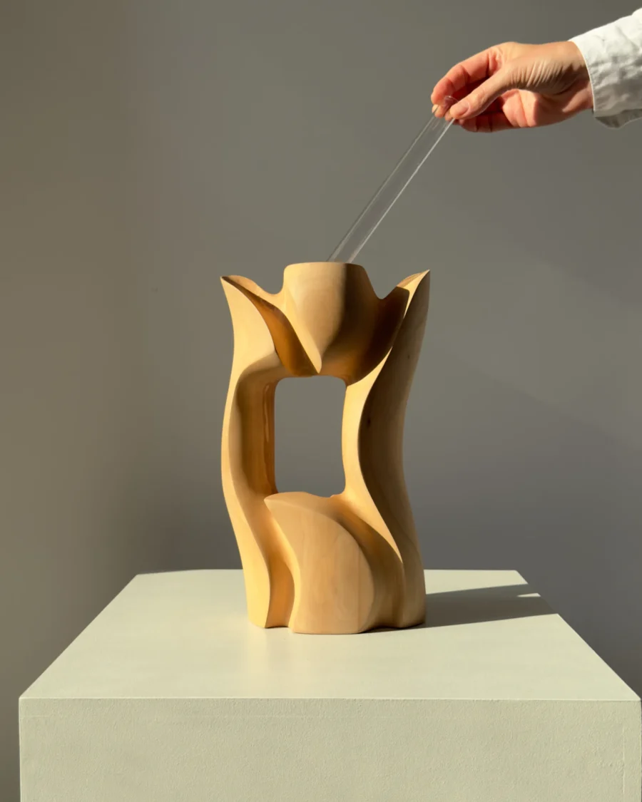 Lumen hand-carved pear wood sculptural vase shown with hands to demonstrate its size and proportions.