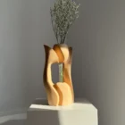 Rear view of Lumen hand-carved pear wood vase with white flowers, showing its open sculptural form.