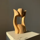 Back view of Lumen, a hand-carved pear wood sculptural vase with an open central space.