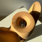 Top opening detail of Lumen showing the carved cavity and removable glass tube inside solid pear wood.