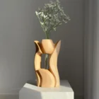 Lumen hand-carved pear wood sculptural vase with delicate white flowers in warm natural light.