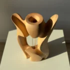 Top view of Lumen hand-carved pear wood sculpture revealing its flowing organic geometry.